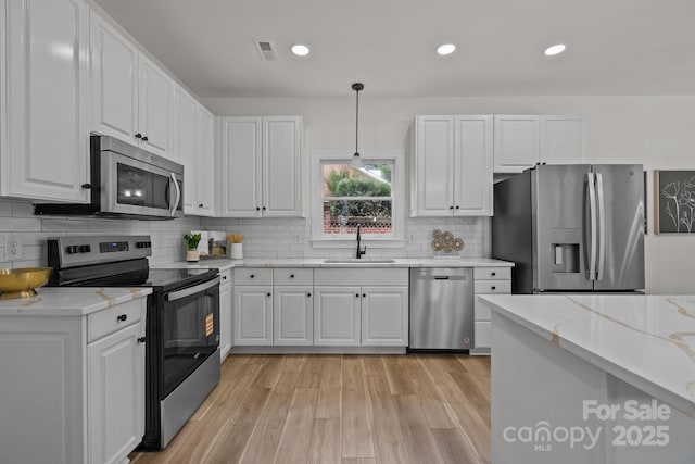 7213 Baniff Cir, Charlotte, NC 28277 - kitchen featuring stainless steel appliances, white cabinetry, decorative backsplash, decorative light fixtures, and light stone countertops
