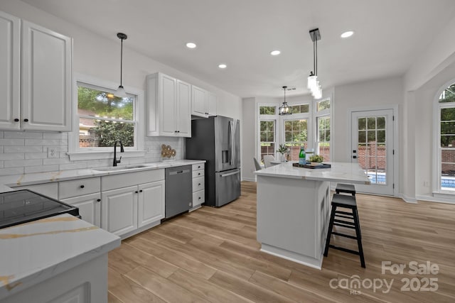 7213 Baniff Cir, Charlotte, NC 28277 - kitchen featuring stainless steel appliances, white cabinetry, decorative backsplash, a kitchen island, and recessed lighting