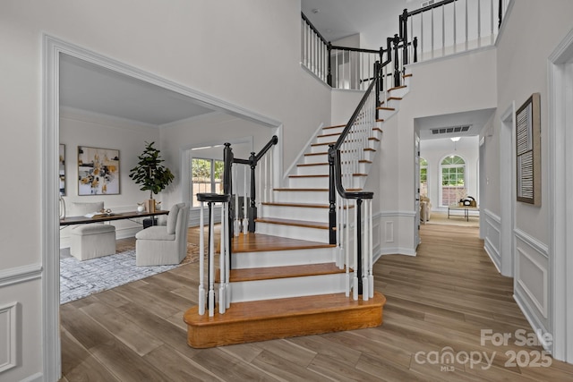 7213 Baniff Cir, Charlotte, NC 28277 - stairs featuring wood finished floors, a towering ceiling, and ornamental molding