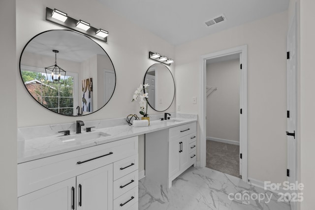 7213 Baniff Cir, Charlotte, NC 28277 - bathroom featuring marble look tile flooring, double vanity, a chandelier, and a spacious closet