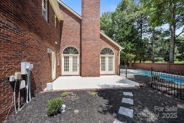 7213 Baniff Cir, Charlotte, NC 28277 - back of property featuring a chimney, brick siding, french doors, and a patio area