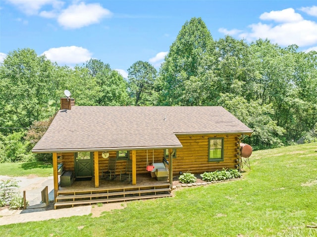 367 Robinson Rd, Clyde, NC 28721 - view of front of property with log siding, roof with shingles, a chimney, and a front lawn