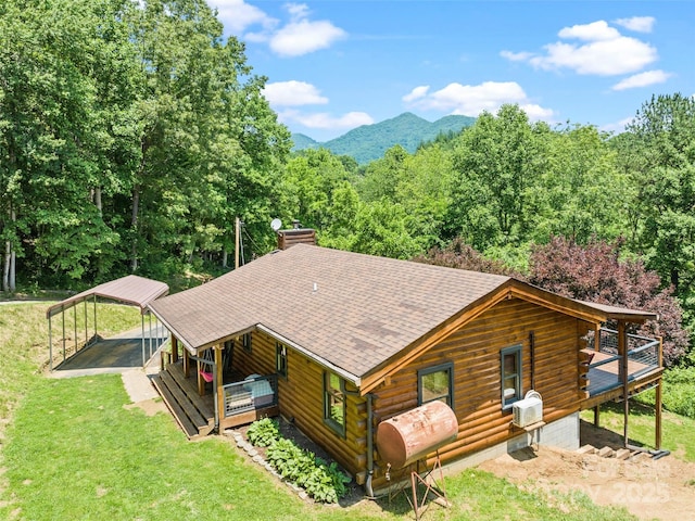 367 Robinson Rd, Clyde, NC 28721 - view of front of home with a detached carport, a front lawn, log exterior, a shingled roof, and a chimney