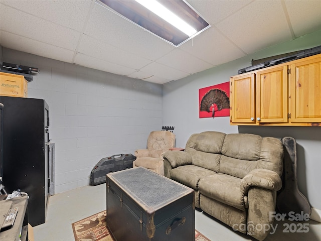 367 Robinson Rd, Clyde, NC 28721 - living room featuring concrete flooring, a drop ceiling, and concrete block wall