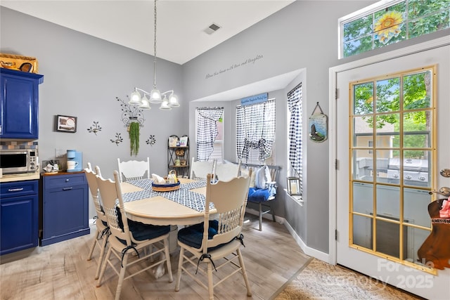 256 Rose St, Mooresville, NC 28117 - dining area featuring light wood finished floors, a chandelier, and high vaulted ceiling
