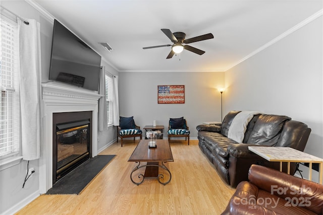 9637 Brookmere Ln, Charlotte, NC 28214 - living room featuring a ceiling fan, wood finished floors, a glass covered fireplace, baseboards, and ornamental molding