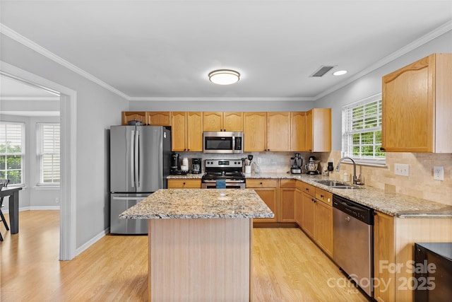 9637 Brookmere Ln, Charlotte, NC 28214 - kitchen with appliances with stainless steel finishes, a sink, light wood-style flooring, light stone counters, and ornamental molding