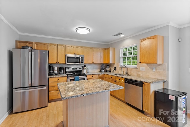 9637 Brookmere Ln, Charlotte, NC 28214 - kitchen featuring appliances with stainless steel finishes, a sink, light wood-style floors, light brown cabinetry, and light stone countertops
