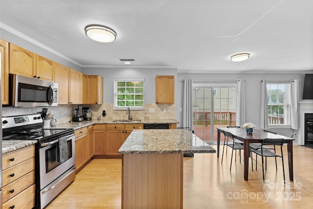 9637 Brookmere Ln, Charlotte, NC 28214 - kitchen with appliances with stainless steel finishes, a sink, light wood finished floors, light brown cabinets, and tasteful backsplash