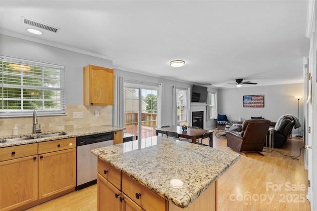 9637 Brookmere Ln, Charlotte, NC 28214 - kitchen with dishwasher, a sink, a glass covered fireplace, a kitchen island, and light wood-style flooring