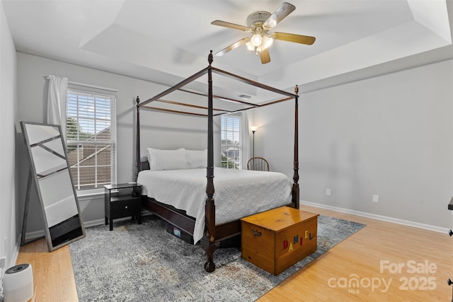 9637 Brookmere Ln, Charlotte, NC 28214 - bedroom featuring multiple windows, wood finished floors, a raised ceiling, and baseboards