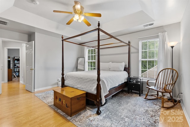 9637 Brookmere Ln, Charlotte, NC 28214 - bedroom featuring baseboards, wood finished floors, a tray ceiling, and ceiling fan
