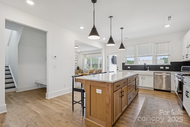 12001 Sam Snead Ct, Lancaster, SC 29720 - kitchen featuring stainless steel appliances, a kitchen breakfast bar, backsplash, a kitchen island, and white cabinetry
