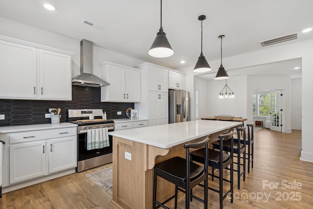 12001 Sam Snead Ct, Lancaster, SC 29720 - kitchen with stainless steel appliances, wall chimney range hood, a center island, light wood finished floors, and tasteful backsplash