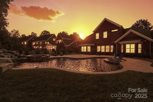 2504 River Oaks Dr, Waxhaw, NC 28173 - pool at dusk featuring a patio, a pool with connected hot tub, and a yard