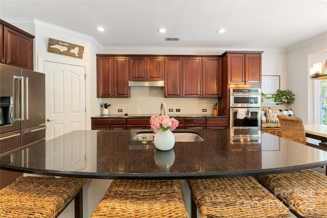 2504 River Oaks Dr, Waxhaw, NC 28173 - kitchen featuring stainless steel appliances, ornamental molding, a kitchen breakfast bar, recessed lighting, and under cabinet range hood