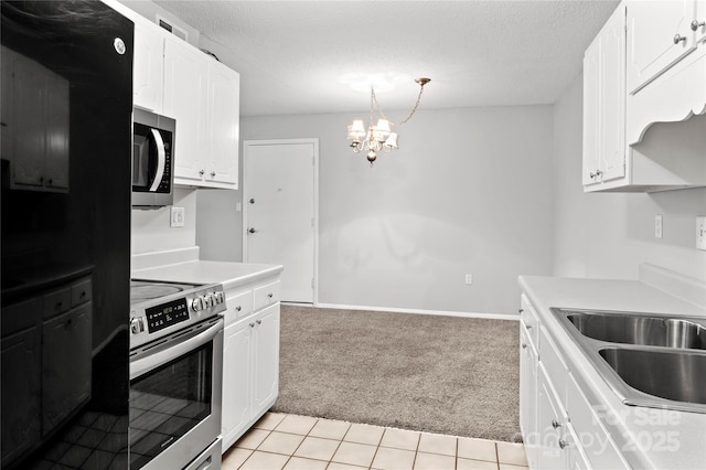 2205 Sunderland Rd Unit 129D, Winston Salem, NC 27103 - kitchen featuring appliances with stainless steel finishes, light carpet, a chandelier, light countertops, and white cabinetry