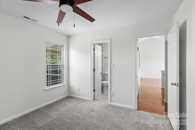 4111 Alexis Ct SW, Concord, NC 28027 - unfurnished bedroom with a textured ceiling, carpet flooring, connected bathroom, and ceiling fan