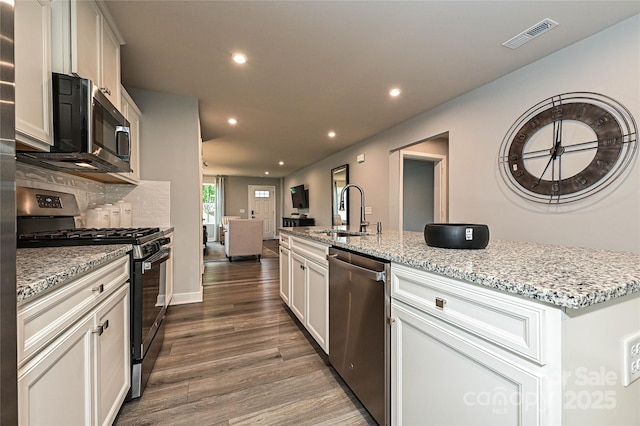 124 Kristin View Ln Unit Townhome A, Troutman, NC 28166 - kitchen with appliances with stainless steel finishes, dark wood finished floors, recessed lighting, light stone countertops, and open floor plan