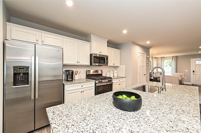 124 Kristin View Ln Unit Townhome A, Troutman, NC 28166 - kitchen with appliances with stainless steel finishes, white cabinets, recessed lighting, light stone countertops, and tasteful backsplash
