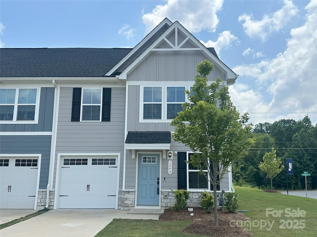 124 Kristin View Ln Unit Townhome A, Troutman, NC 28166 - view of front of property featuring board and batten siding, concrete driveway, an attached garage, and stone siding