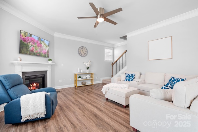 3038 Burnello Ct, Iron Station, NC 28080 - living area with ornamental molding, a glass covered fireplace, wood finished floors, ceiling fan, and stairs