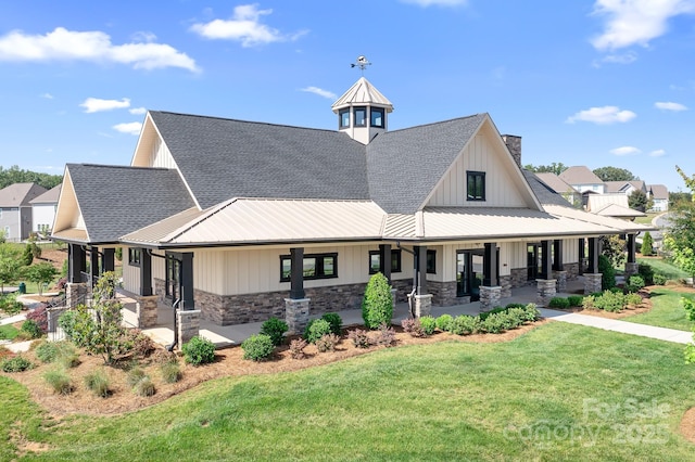 3038 Burnello Ct, Iron Station, NC 28080 - view of front of home with stone siding, a front yard, a chimney, and a standing seam roof