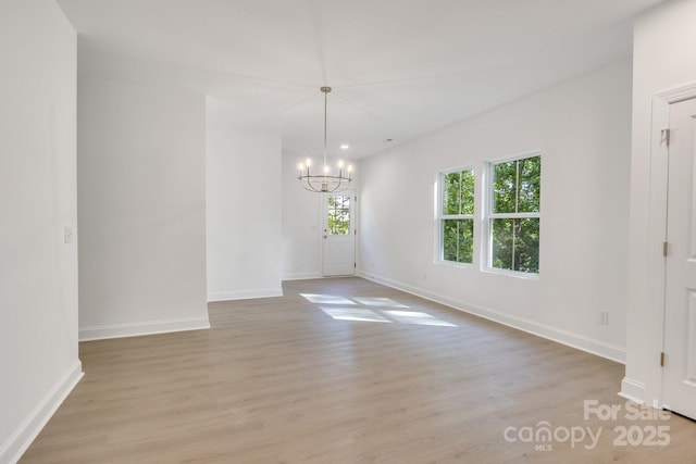 5175 Grand Canyon Rd, Concord, NC 28027 - unfurnished room with plenty of natural light, a chandelier, light wood-style floors, and baseboards