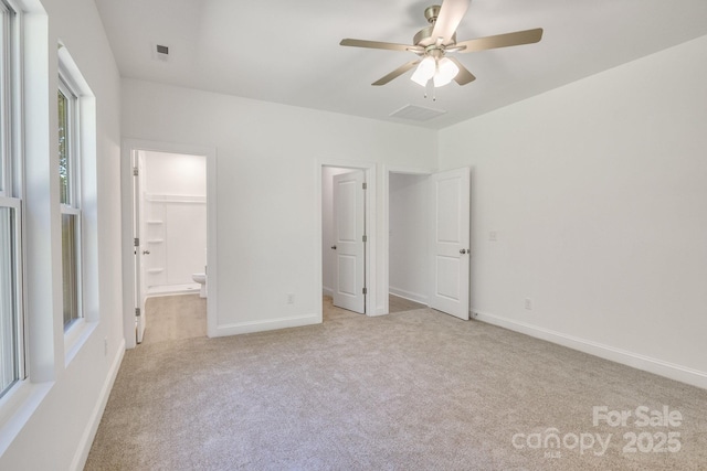 5175 Grand Canyon Rd, Concord, NC 28027 - unfurnished bedroom with light colored carpet, ensuite bath, baseboards, a walk in closet, and ceiling fan