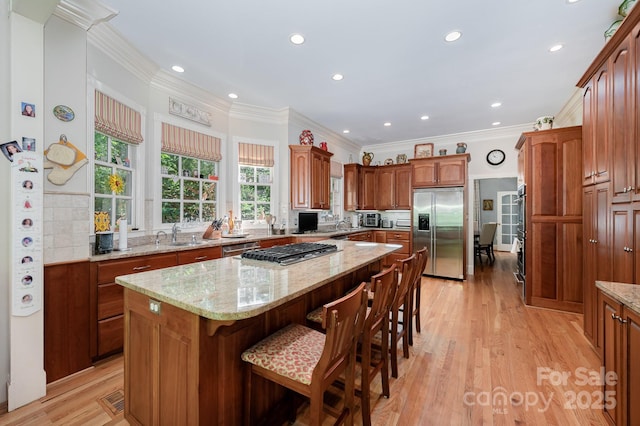 408 Johnsfield Rd, Shelby, NC 28150 - kitchen with appliances with stainless steel finishes, a center island, a breakfast bar, light stone counters, and light wood-type flooring