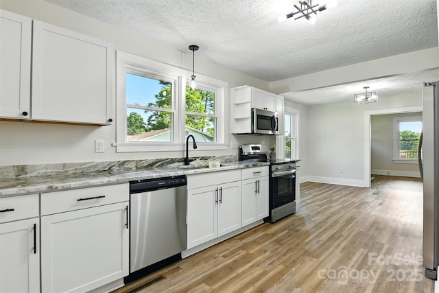 3923 US Highway 321a, Hudson, NC 28638 - kitchen featuring appliances with stainless steel finishes, a sink, a textured ceiling, white cabinets, and light wood-type flooring