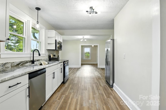 3923 US Highway 321a, Hudson, NC 28638 - kitchen with appliances with stainless steel finishes, light wood-style flooring, white cabinetry, a sink, and a textured ceiling