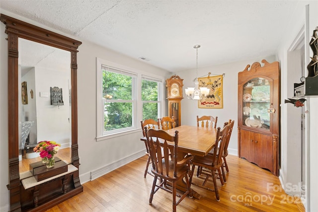 261 Forest Hill Dr, Asheville, NC 28803 - dining room featuring light wood finished floors, a chandelier, a textured ceiling, and a baseboard radiator
