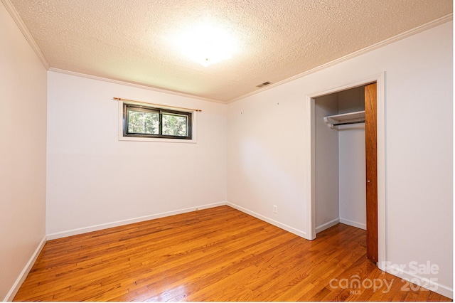 4783 Calico Rd, Lenoir, NC 28645 - unfurnished bedroom with crown molding, light wood finished floors, a textured ceiling, baseboards, and a closet