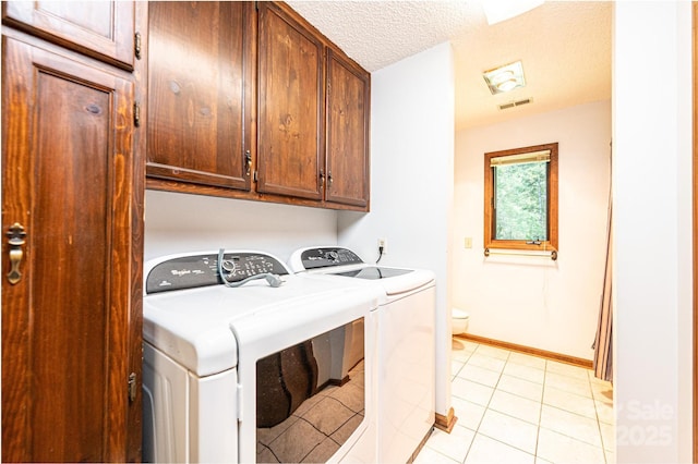 4783 Calico Rd, Lenoir, NC 28645 - washroom featuring separate washer and dryer, cabinet space, a textured ceiling, and light tile patterned floors