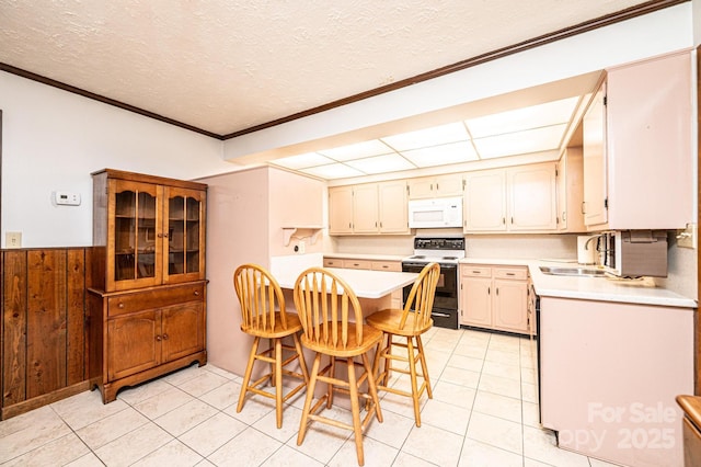 4783 Calico Rd, Lenoir, NC 28645 - kitchen featuring range with electric stovetop, white microwave, light countertops, light tile patterned floors, and a breakfast bar area