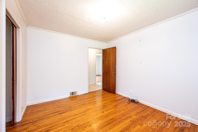 4783 Calico Rd, Lenoir, NC 28645 - unfurnished bedroom featuring crown molding, light wood finished floors, and a textured ceiling