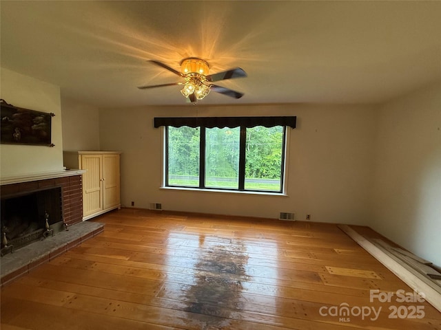4783 Calico Rd, Lenoir, NC 28645 - unfurnished living room featuring light wood-style floors, a brick fireplace, and ceiling fan