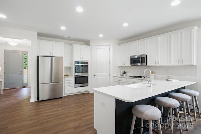 16112 Langston Dr, Charlotte, NC 28278 - kitchen with appliances with stainless steel finishes, decorative backsplash, recessed lighting, a breakfast bar area, and dark wood-style floors