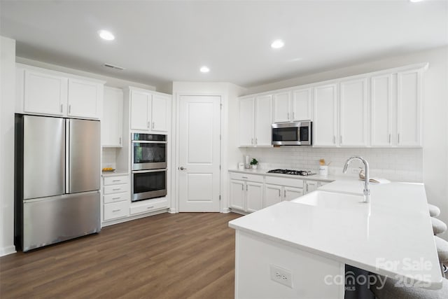 16112 Langston Dr, Charlotte, NC 28278 - kitchen featuring stainless steel appliances, backsplash, white cabinets, dark wood-type flooring, and recessed lighting