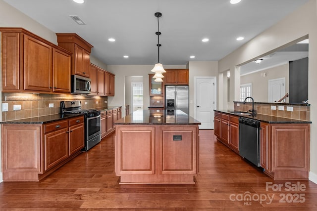 126 Northbridge Dr, Mooresville, NC 28115 - kitchen with stainless steel appliances, a sink, a center island, brown cabinets, and recessed lighting