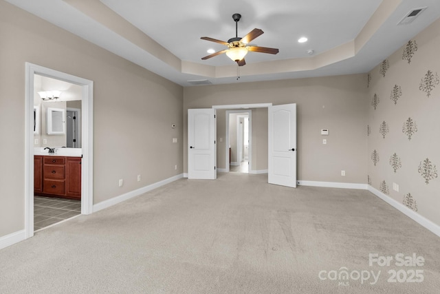 126 Northbridge Dr, Mooresville, NC 28115 - unfurnished bedroom featuring light carpet, baseboards, a sink, a tray ceiling, and ensuite bathroom
