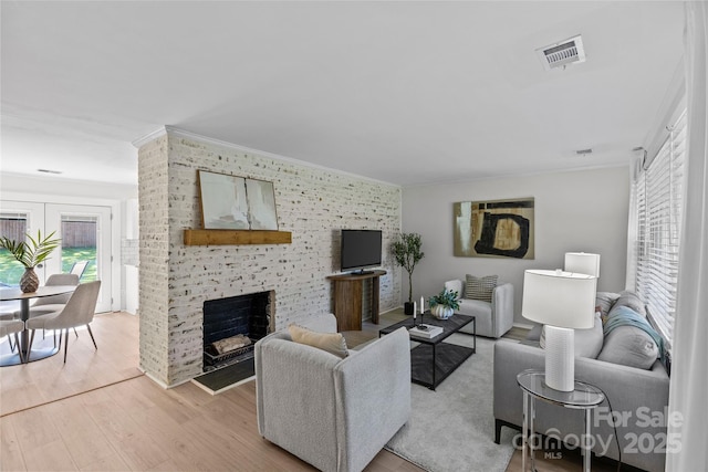 5329 Valley Forge Rd, Charlotte, NC 28210 - living room with ornamental molding, light wood-type flooring, a fireplace, and an accent wall