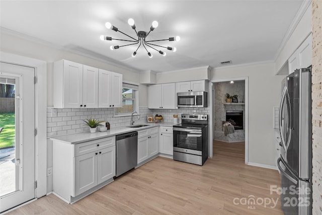 5329 Valley Forge Rd, Charlotte, NC 28210 - kitchen with stainless steel appliances, a chandelier, backsplash, white cabinets, and light wood-type flooring