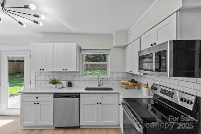 5329 Valley Forge Rd, Charlotte, NC 28210 - kitchen with stainless steel appliances, ornamental molding, light countertops, white cabinetry, and backsplash