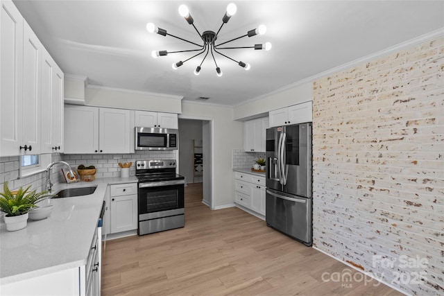 5329 Valley Forge Rd, Charlotte, NC 28210 - kitchen featuring appliances with stainless steel finishes, a chandelier, crown molding, decorative backsplash, and white cabinetry
