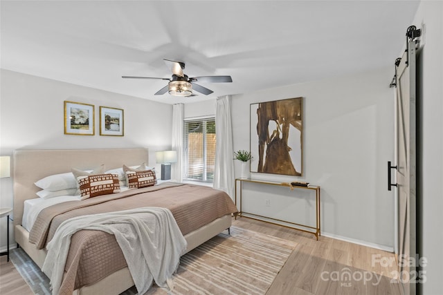 5329 Valley Forge Rd, Charlotte, NC 28210 - bedroom featuring a barn door, wood finished floors, and a ceiling fan