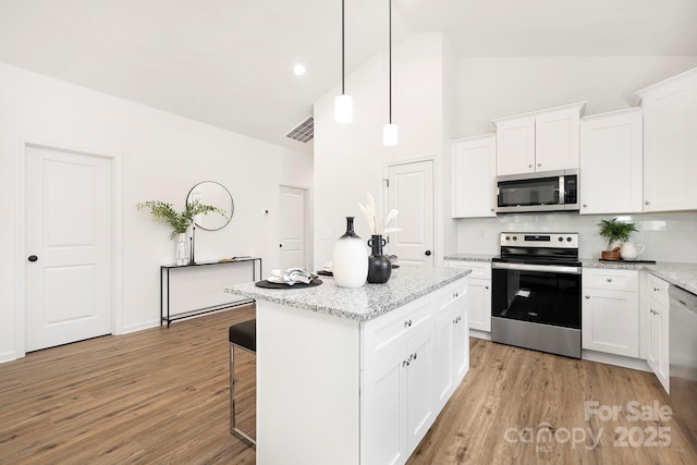 4230 Acorn St, Charlotte, NC 28205 - kitchen with appliances with stainless steel finishes, high vaulted ceiling, light wood-style floors, backsplash, and a kitchen island