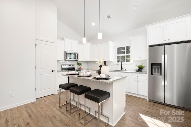 4230 Acorn St, Charlotte, NC 28205 - kitchen with stainless steel appliances, light wood-style flooring, white cabinets, and high vaulted ceiling