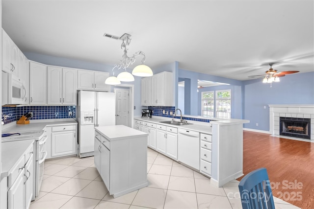 1624 Moonstone Dr, Matthews, NC 28105 - kitchen with white appliances, ceiling fan, tasteful backsplash, light countertops, and white cabinets